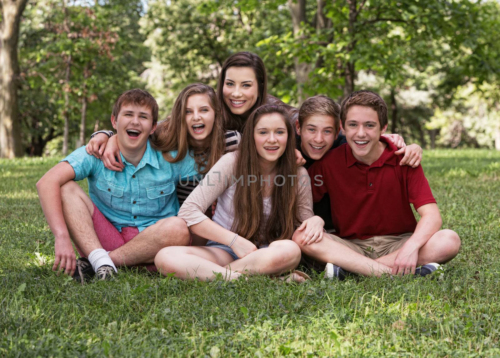 Cute group of six teens outdoors laughing