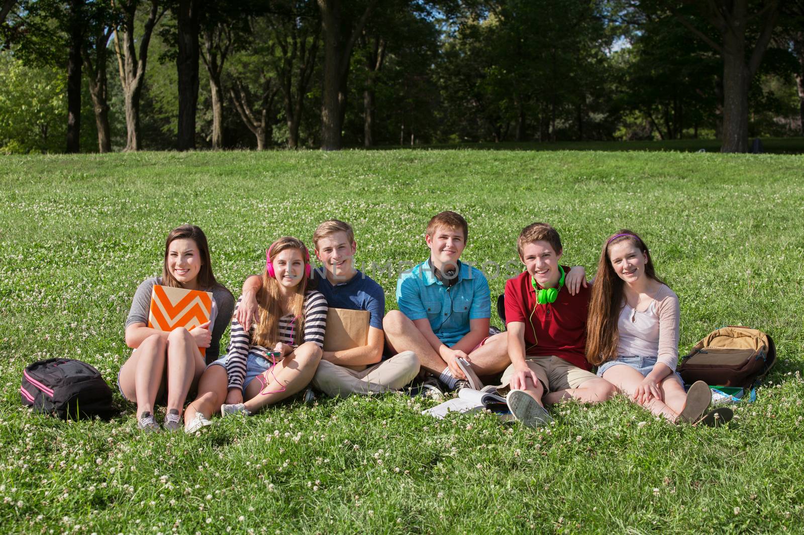 Happy group of teens students with backpacks