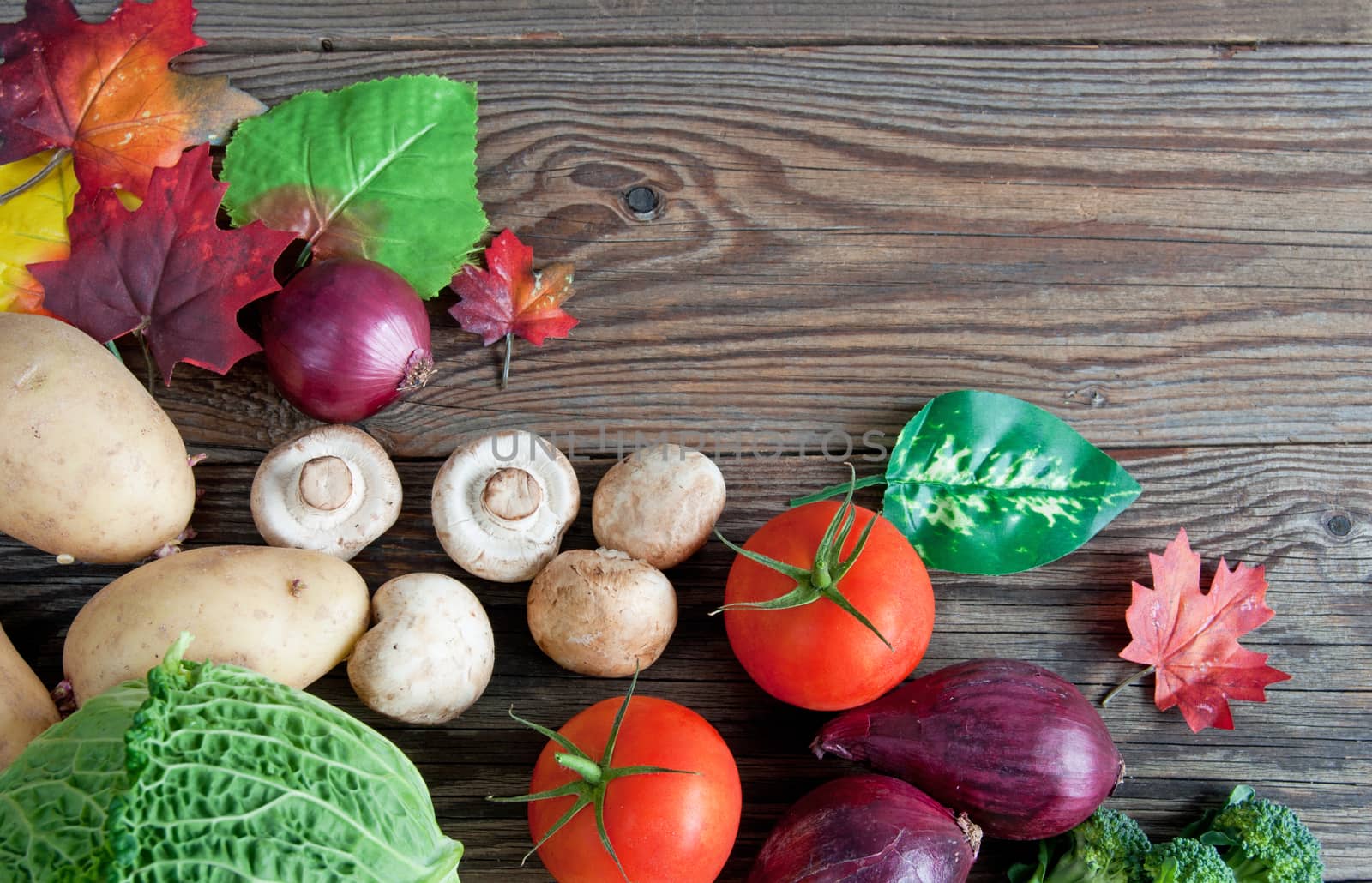 Autumn fruits and vegetables over rustic wood