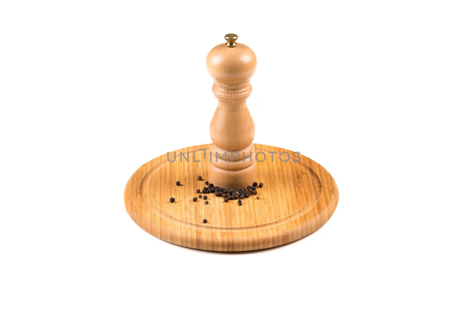 Pepper mill and black peppercorn on wooden board