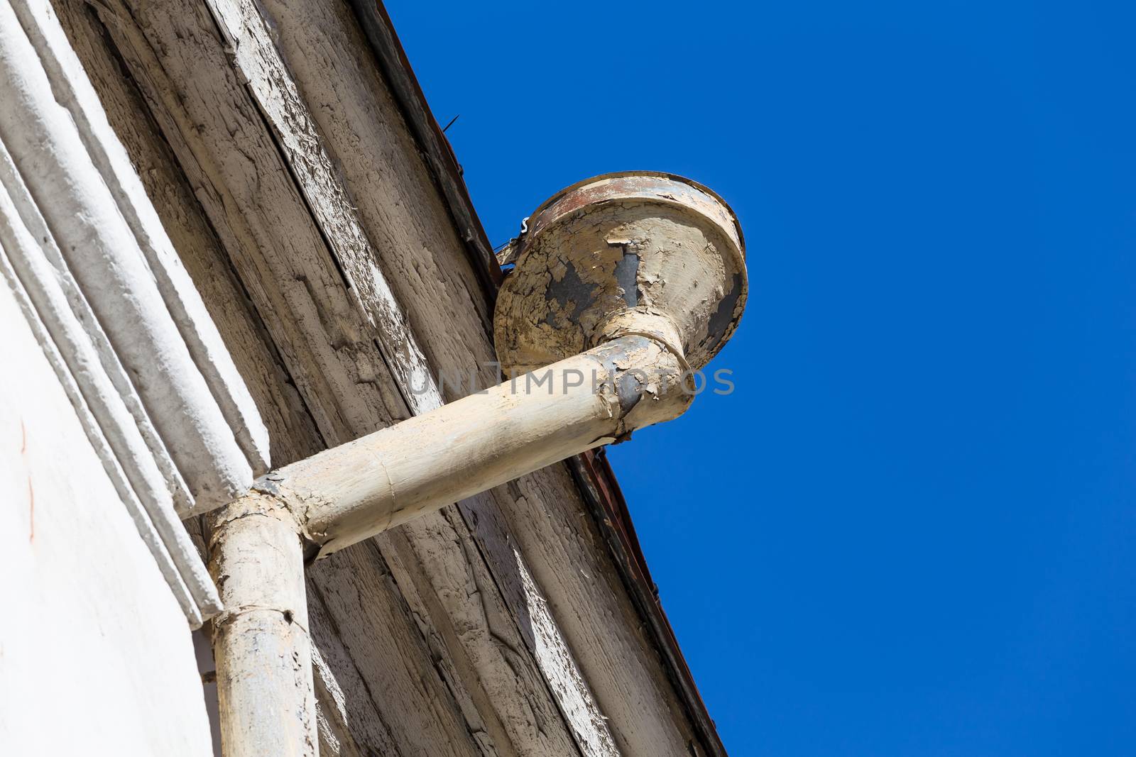 Rain gutters on old home. There is a blue sky in the background.