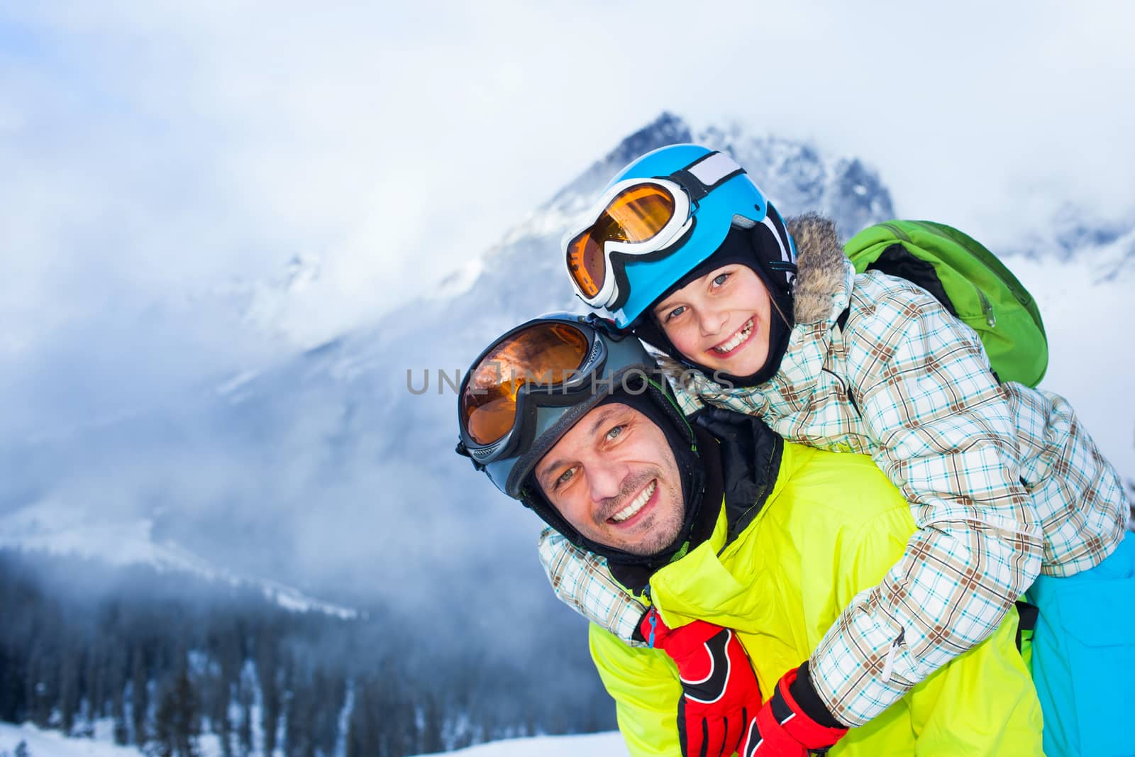 Ski, winter, snow, skiers, sun and fun - Family - father and daughter enjoying winter vacations.