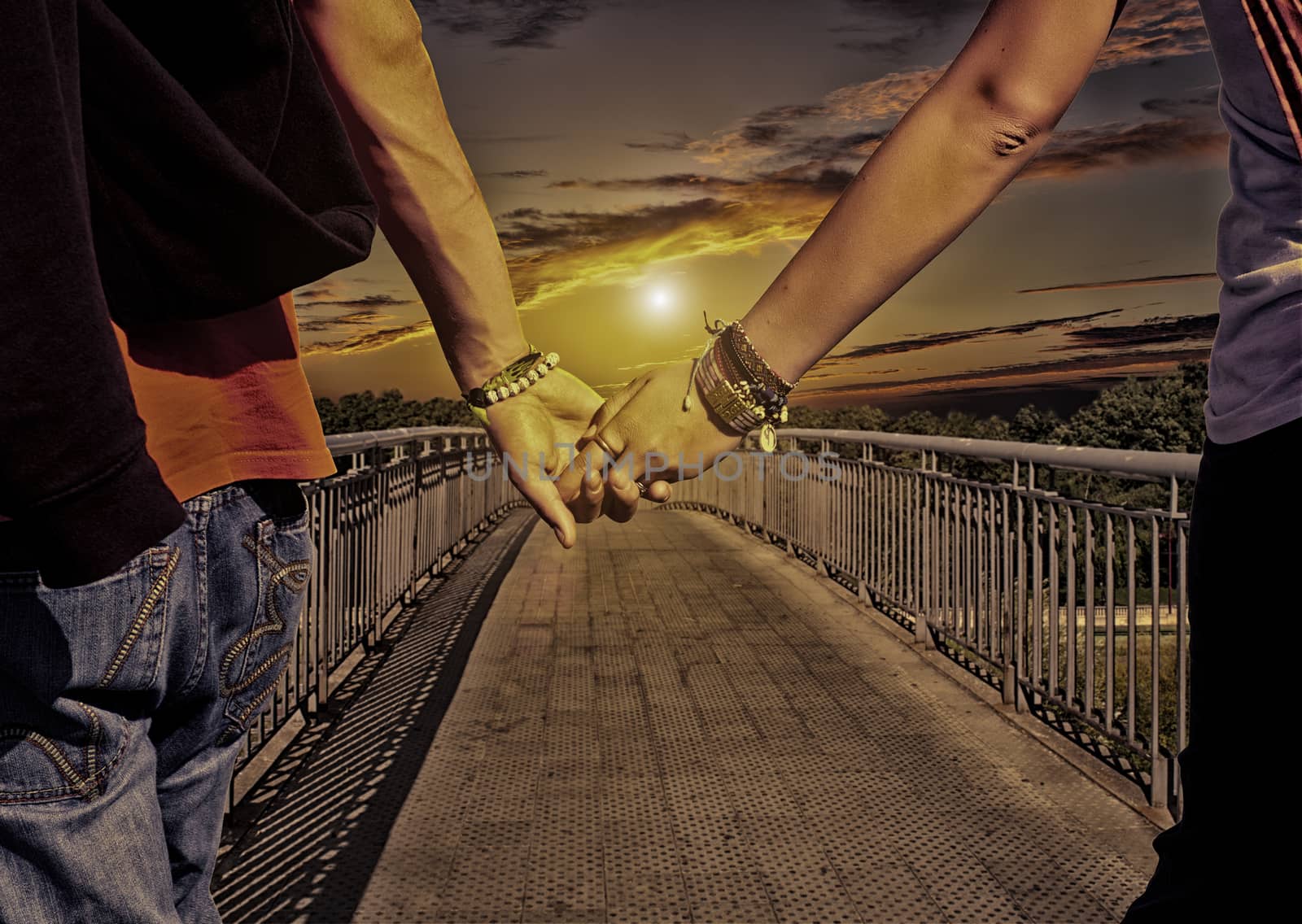 View of lovers couple holding hands on the bridge