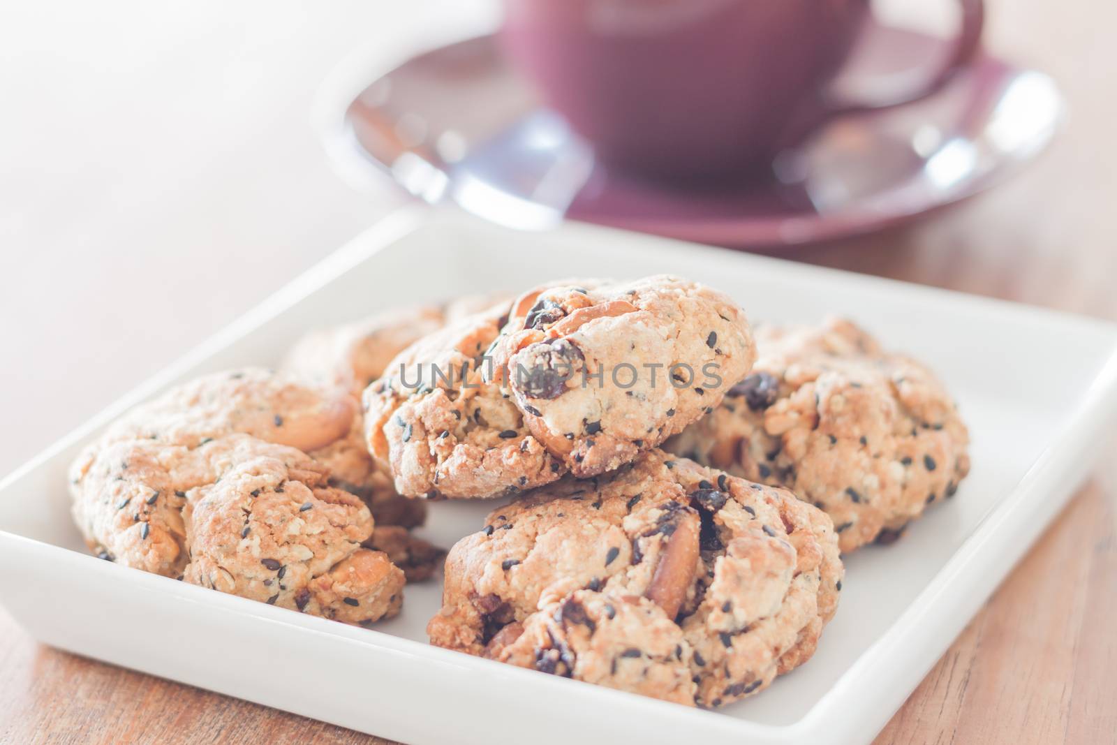 Closeup mixed nut cookies with violet coffee cup, stock photo