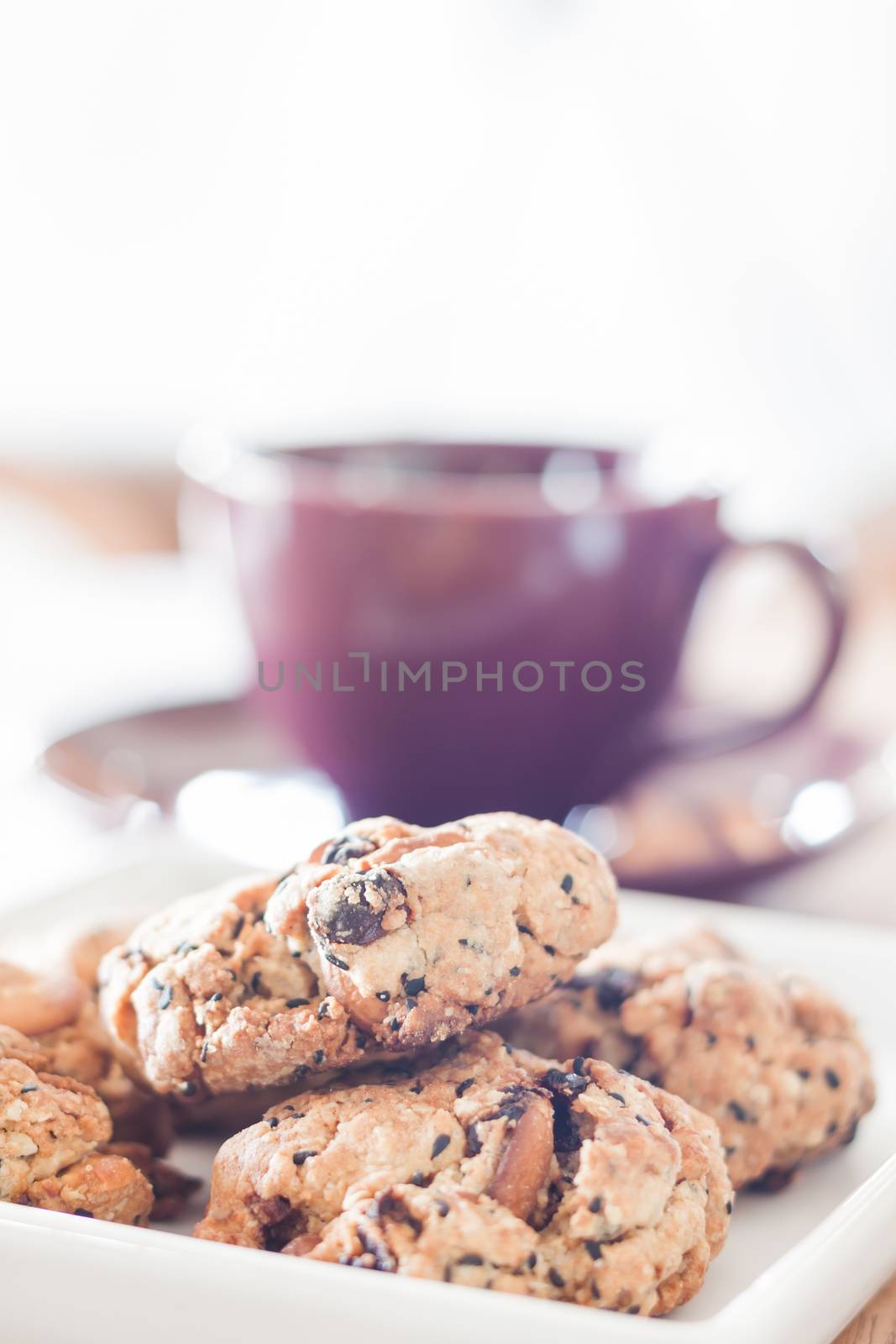 Closeup cereal cookies with violet coffee cup by punsayaporn