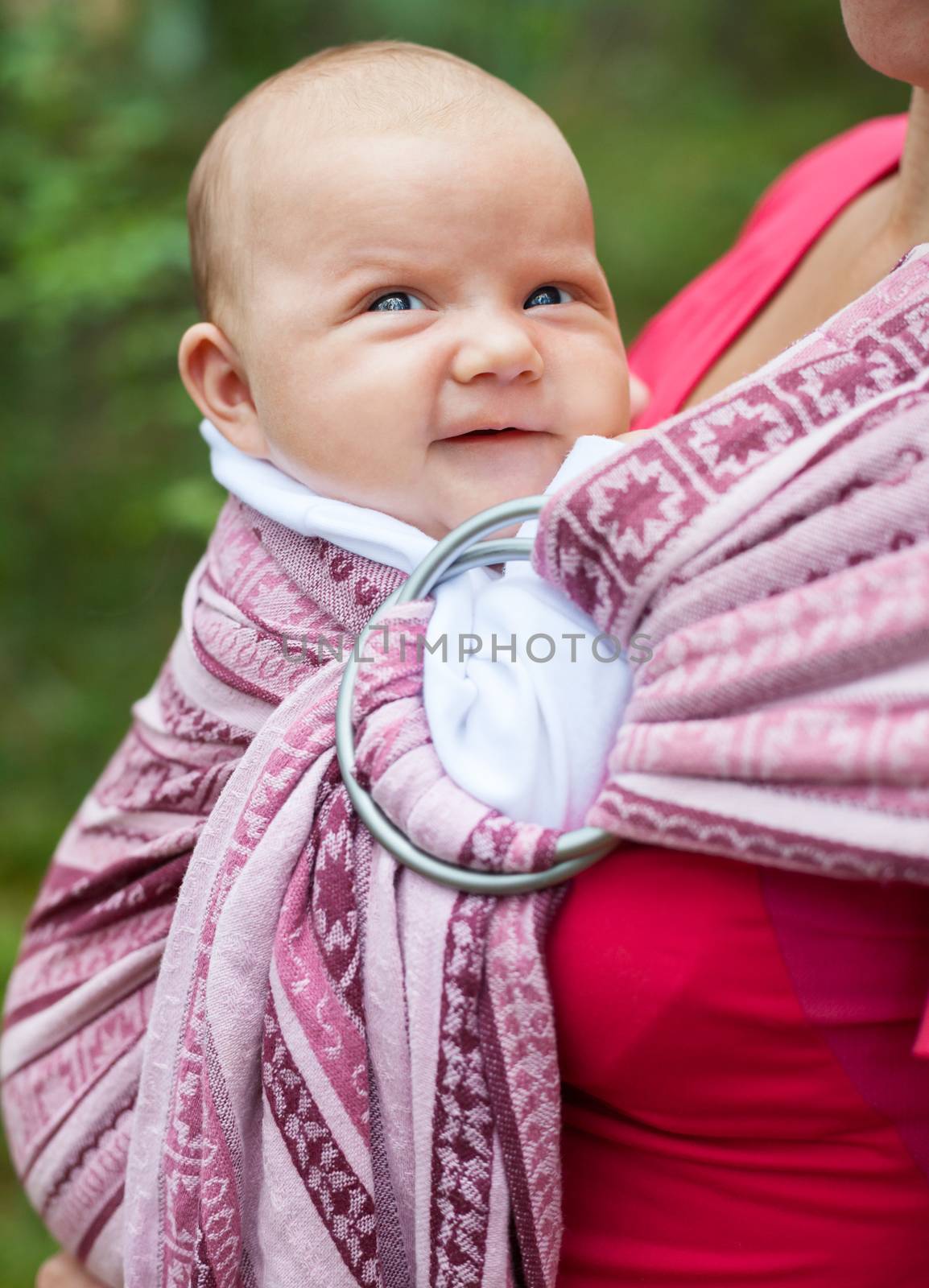 Mother carrying her child in a baby sling