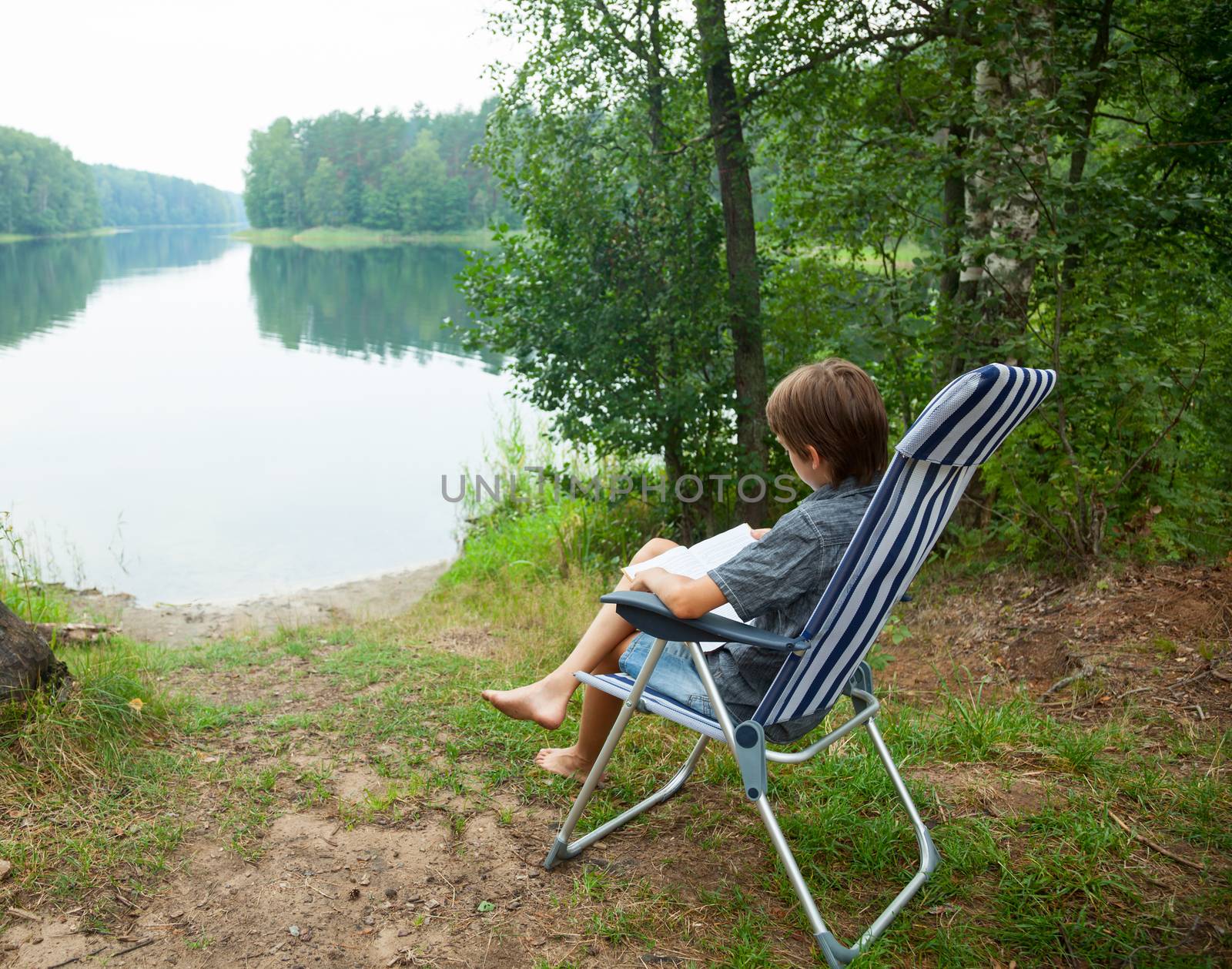 Child reading book outdoor by naumoid