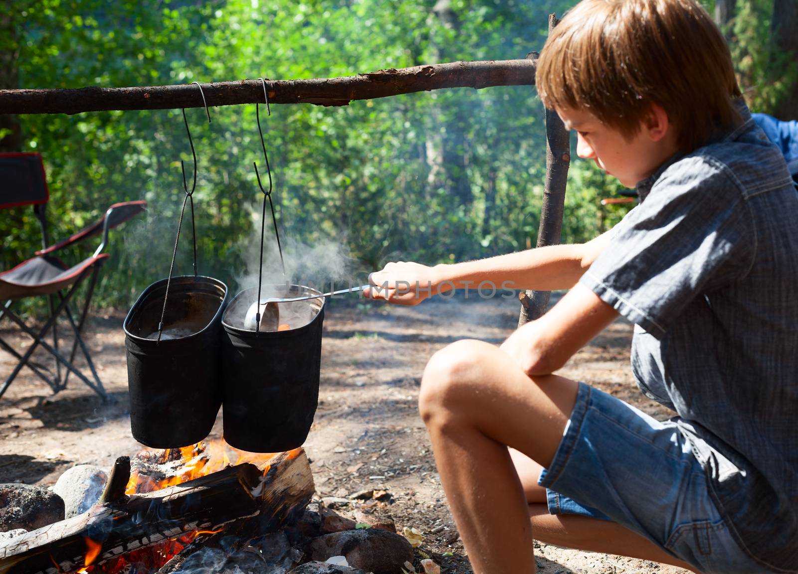 Child cooking on campfire by naumoid