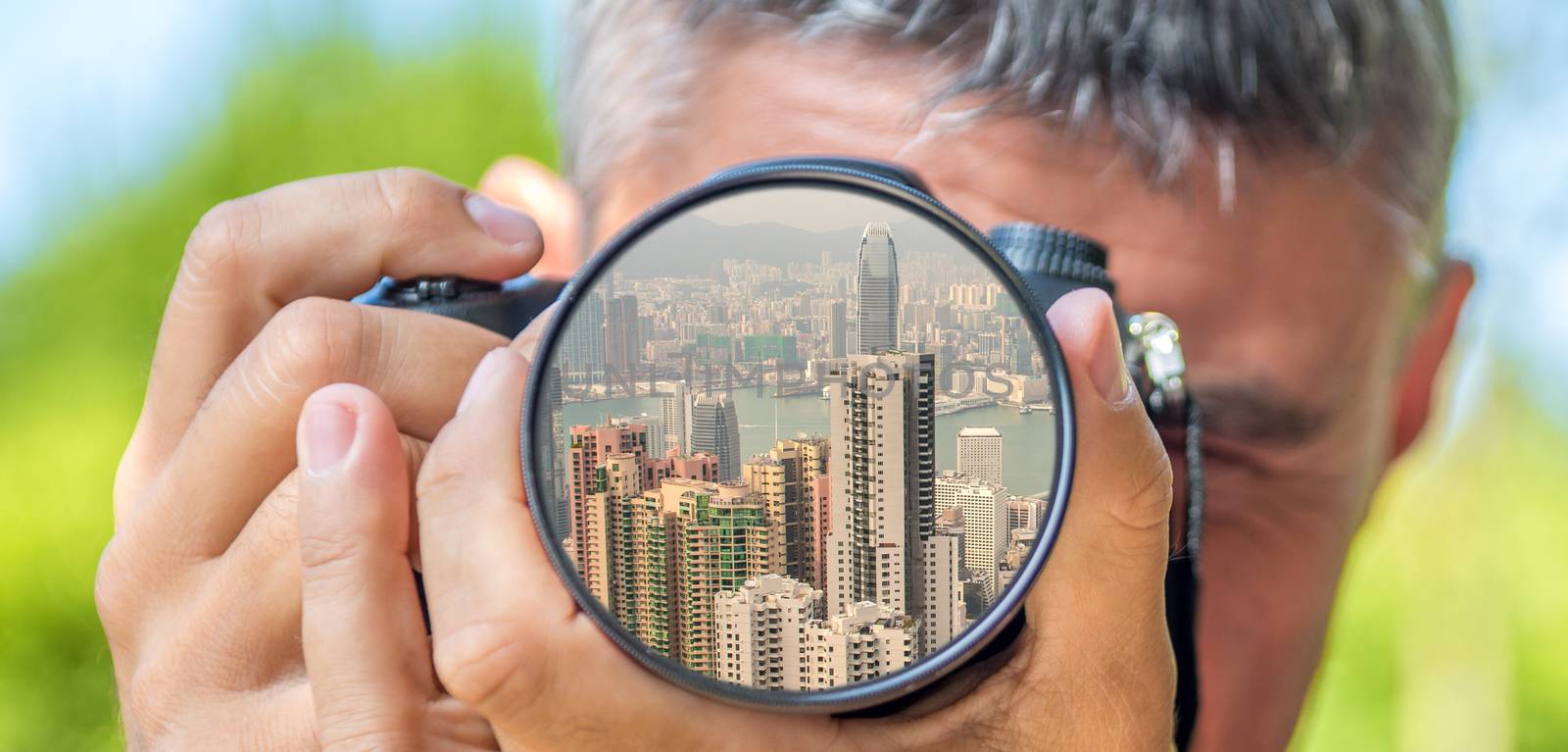 Photographer taking photo with DSLR camera at Hong Kong buildings. Shallow DOF