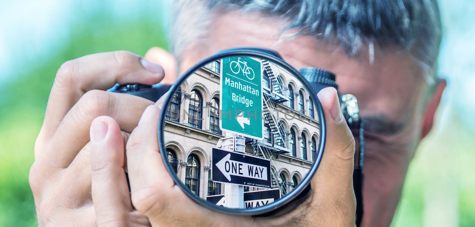 Photographer taking photo with DSLR camera at New York Street Signs. Shallow DOF
