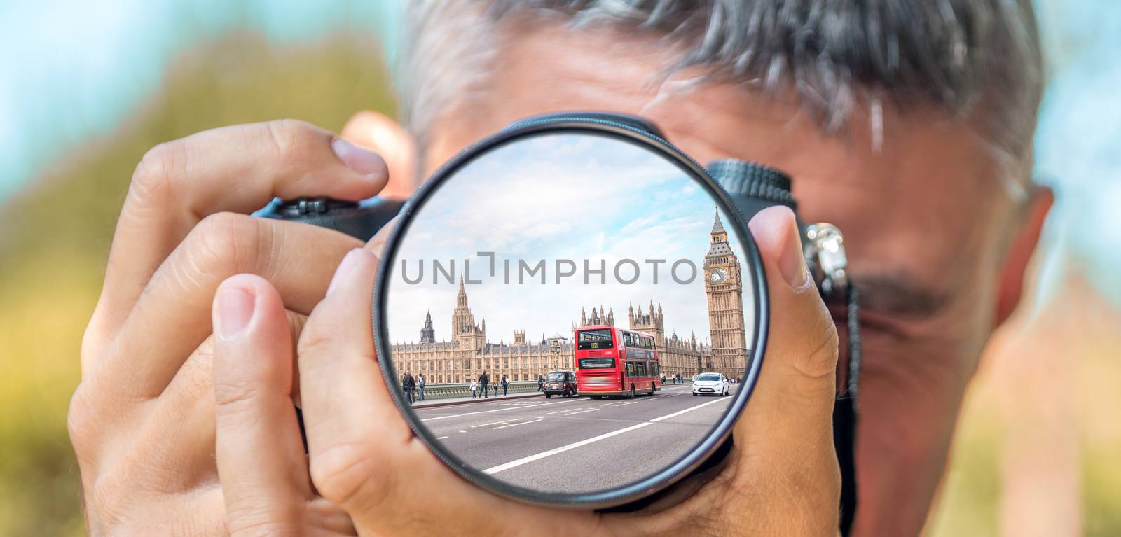 Photographer taking photo with DSLR camera at Bus in Westminster Bridge. Shallow DOF