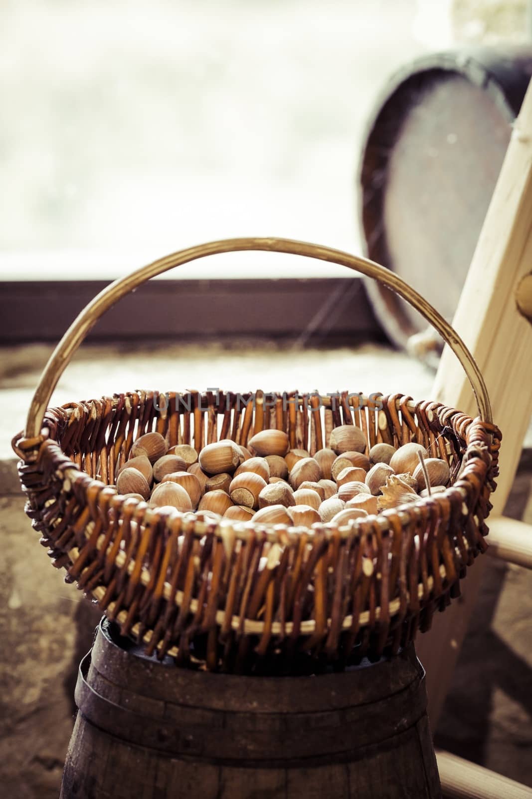 A basket of hazelnuts with a window in background.