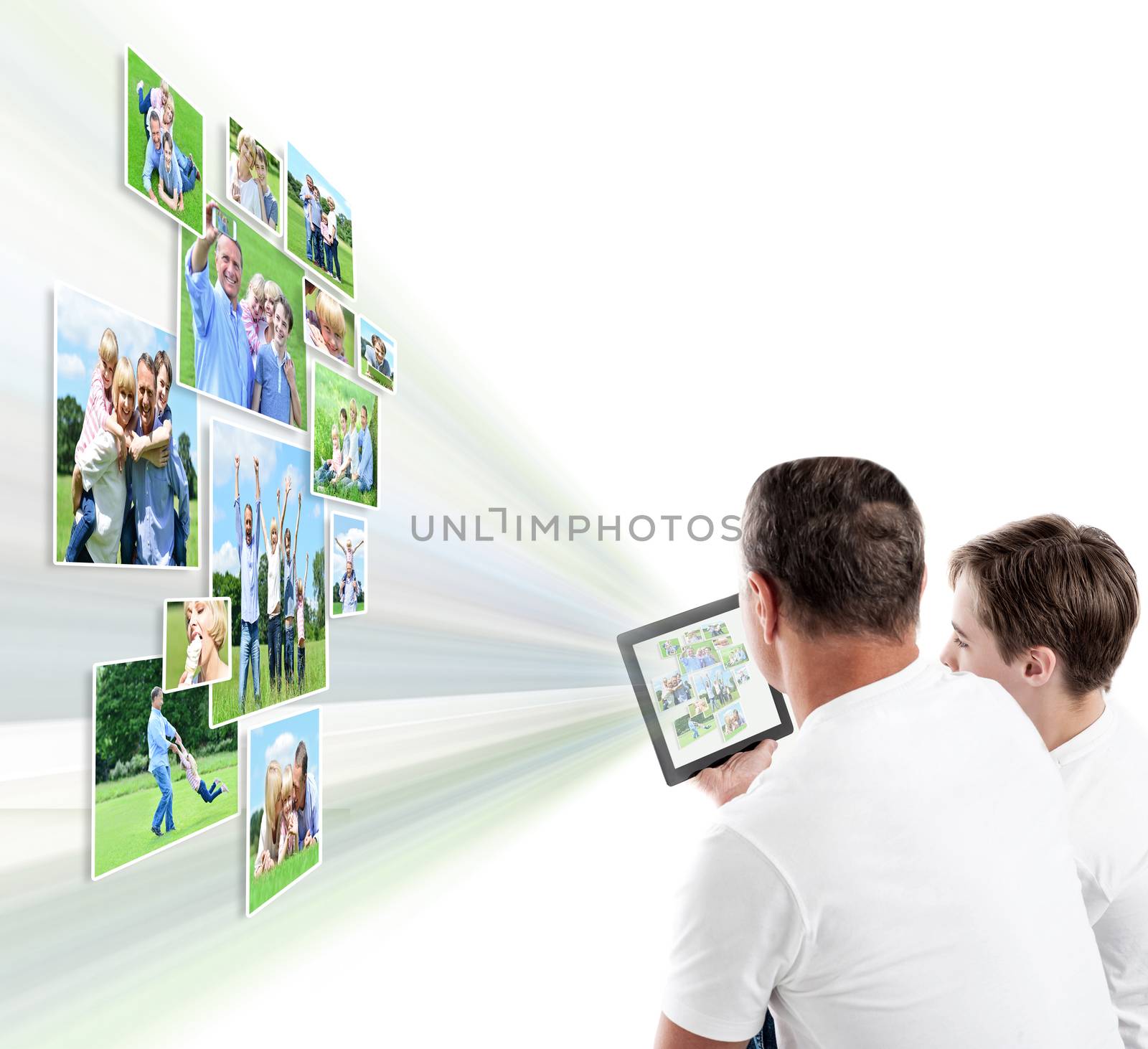 Father and son looking pictures on tablet  by stockyimages