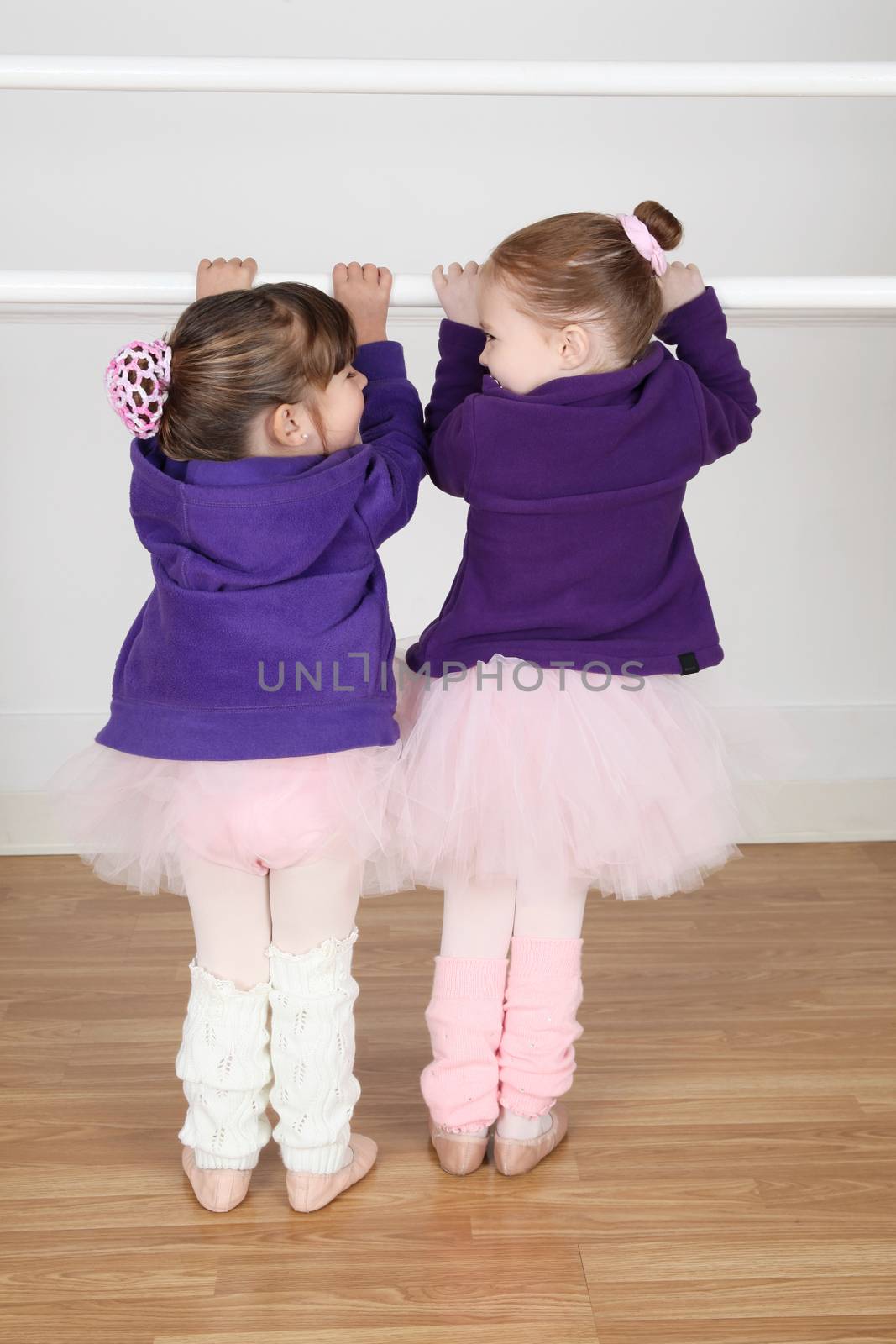 Beautiful little ballet dancers at the dance studio barre 