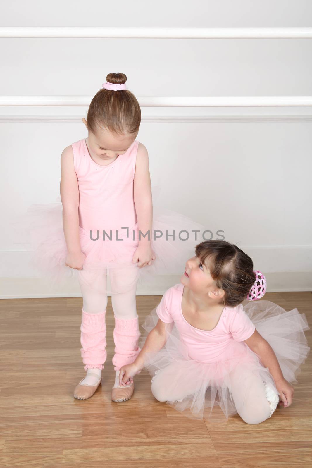 Beautiful little ballet dancers at the dance studio barre 