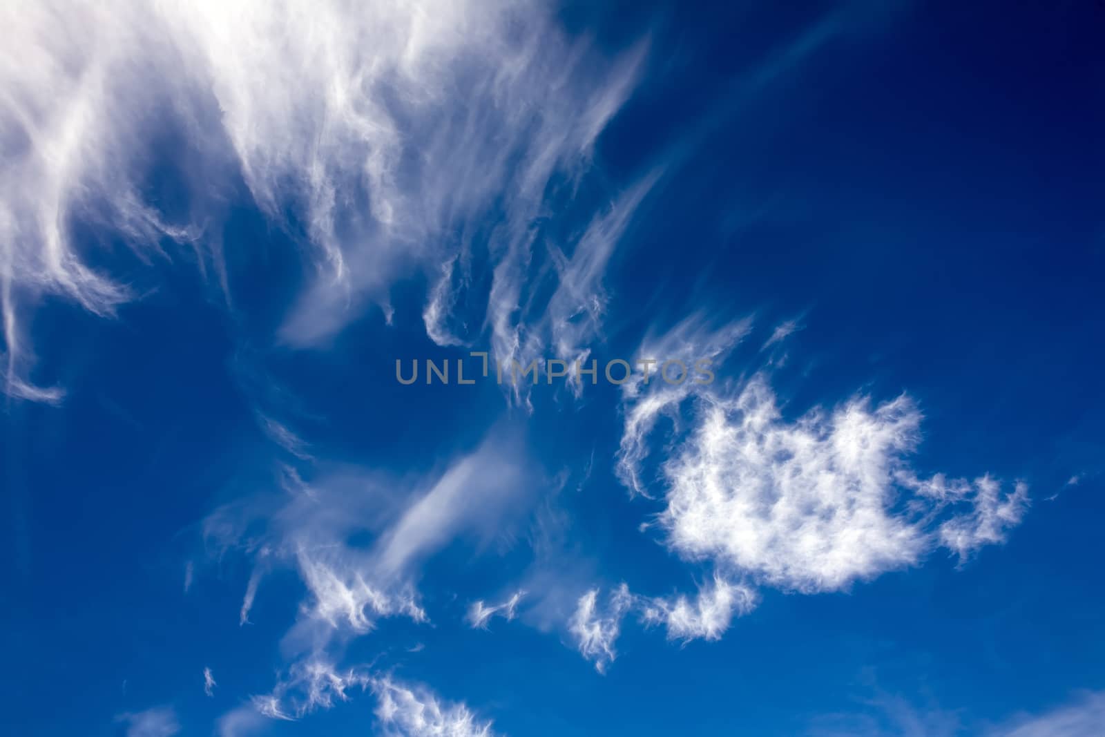 Heavenly landscape on a Sunny windy day - flying high clouds on the blue sky background