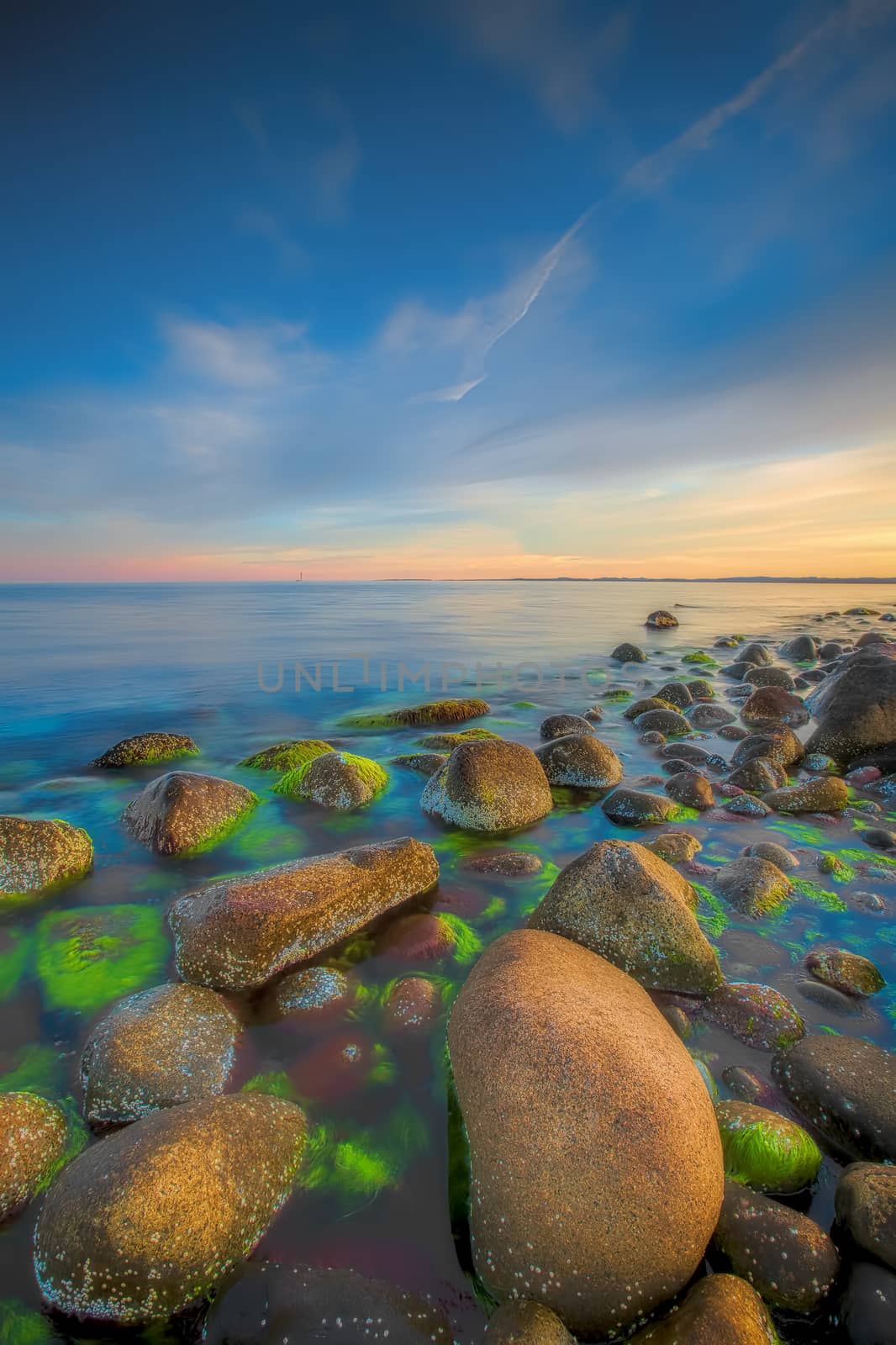 Sunset over the rolling stones of the Norwegian coast, Moelen