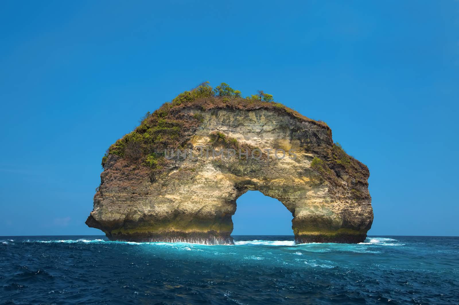 Natural stone arch out on the ocean of Bali, Indonesia