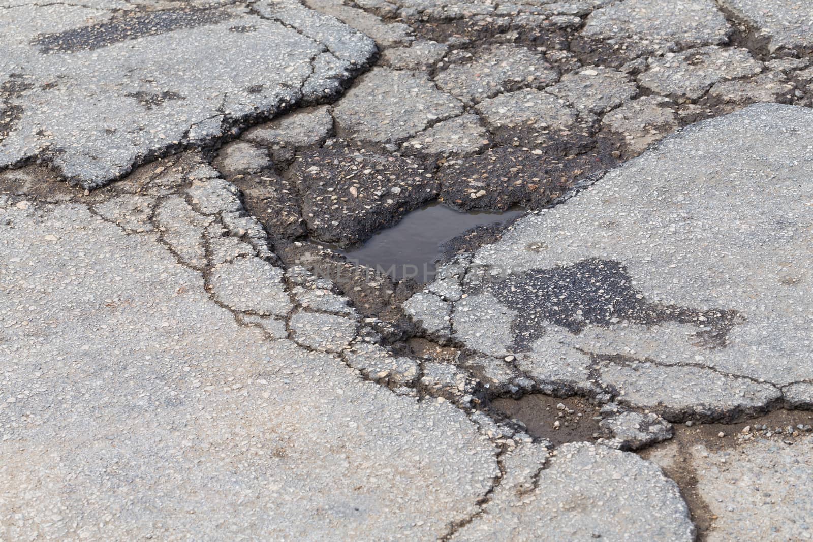 Bad old road, big hole in street asphalt