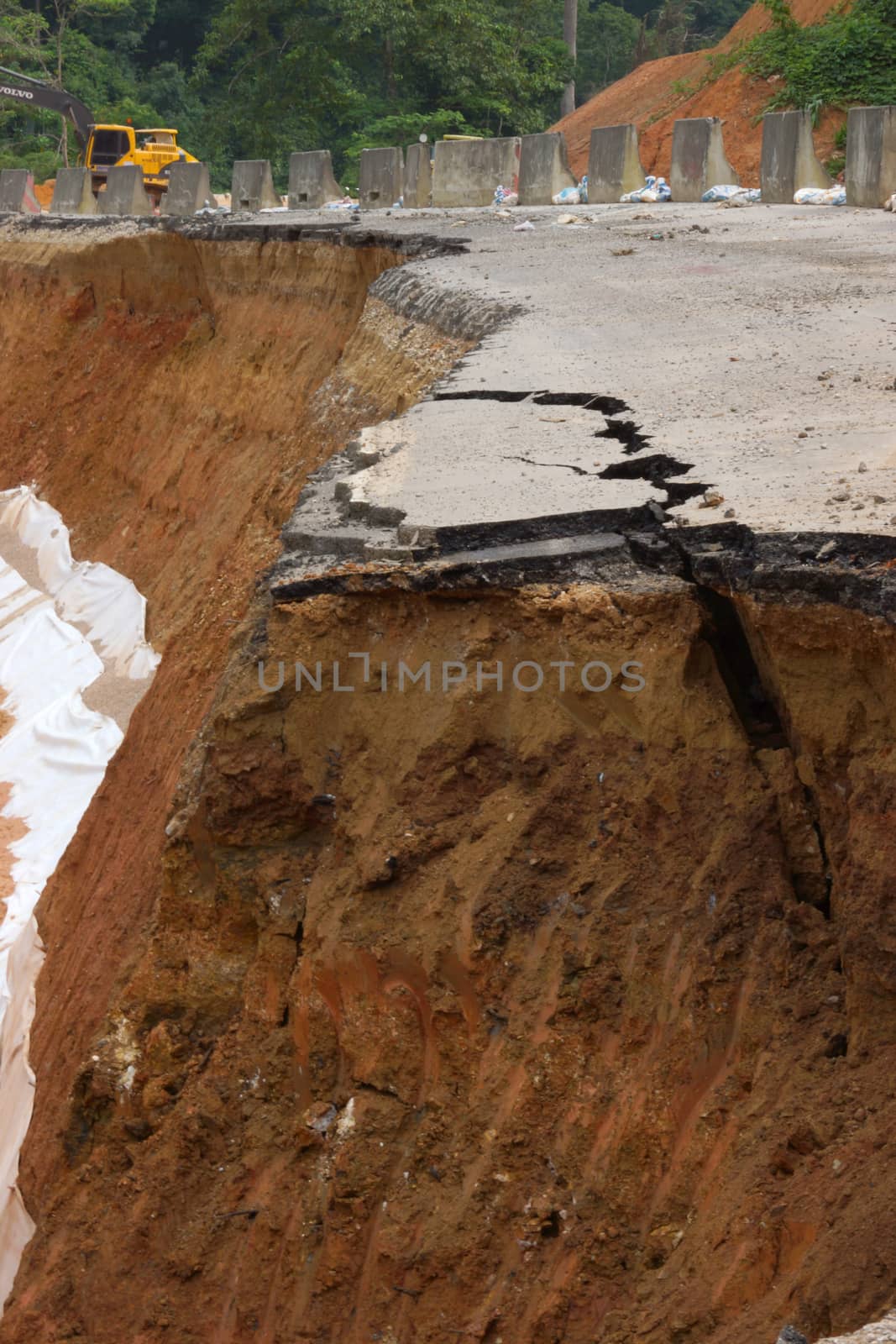 Side of the broken asphalt road collapsed and fallen, since the ground collapsing.