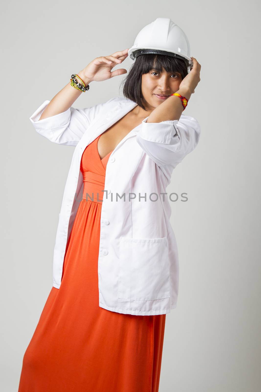 Young philipino engineer, wearing a sexy orange dress, hard hat and a lab coat