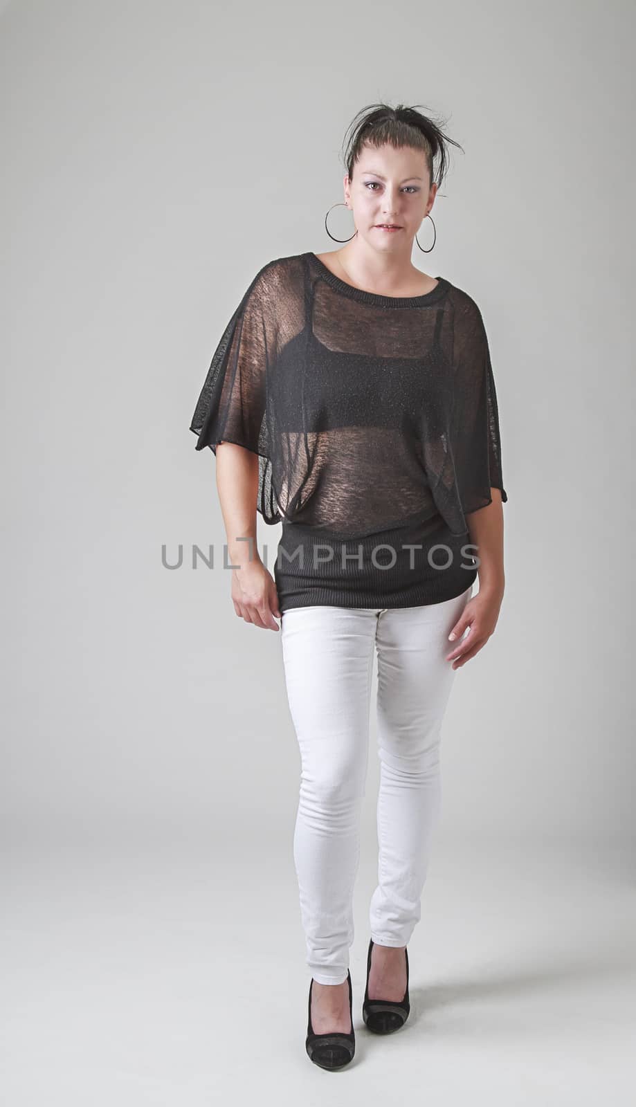 thirty something woman, wearing a transparent shirt, taking one step