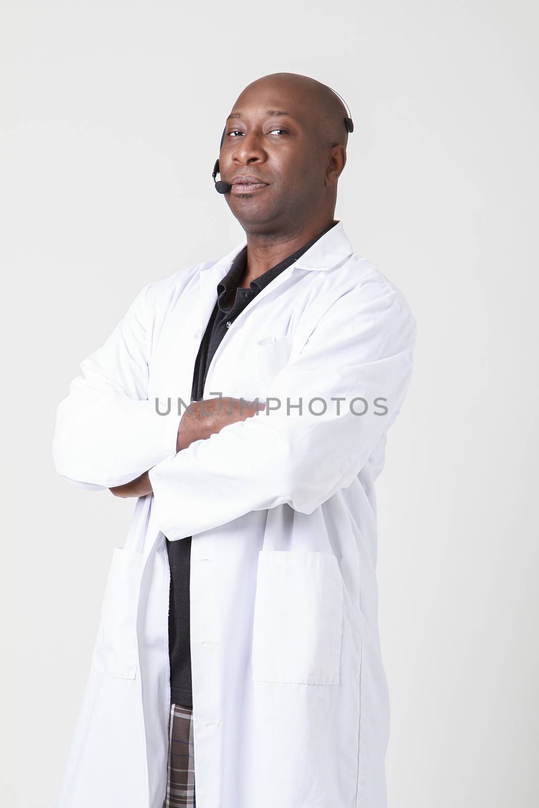 Forty year old black man, wearing a lab coat with telephone headset on his head