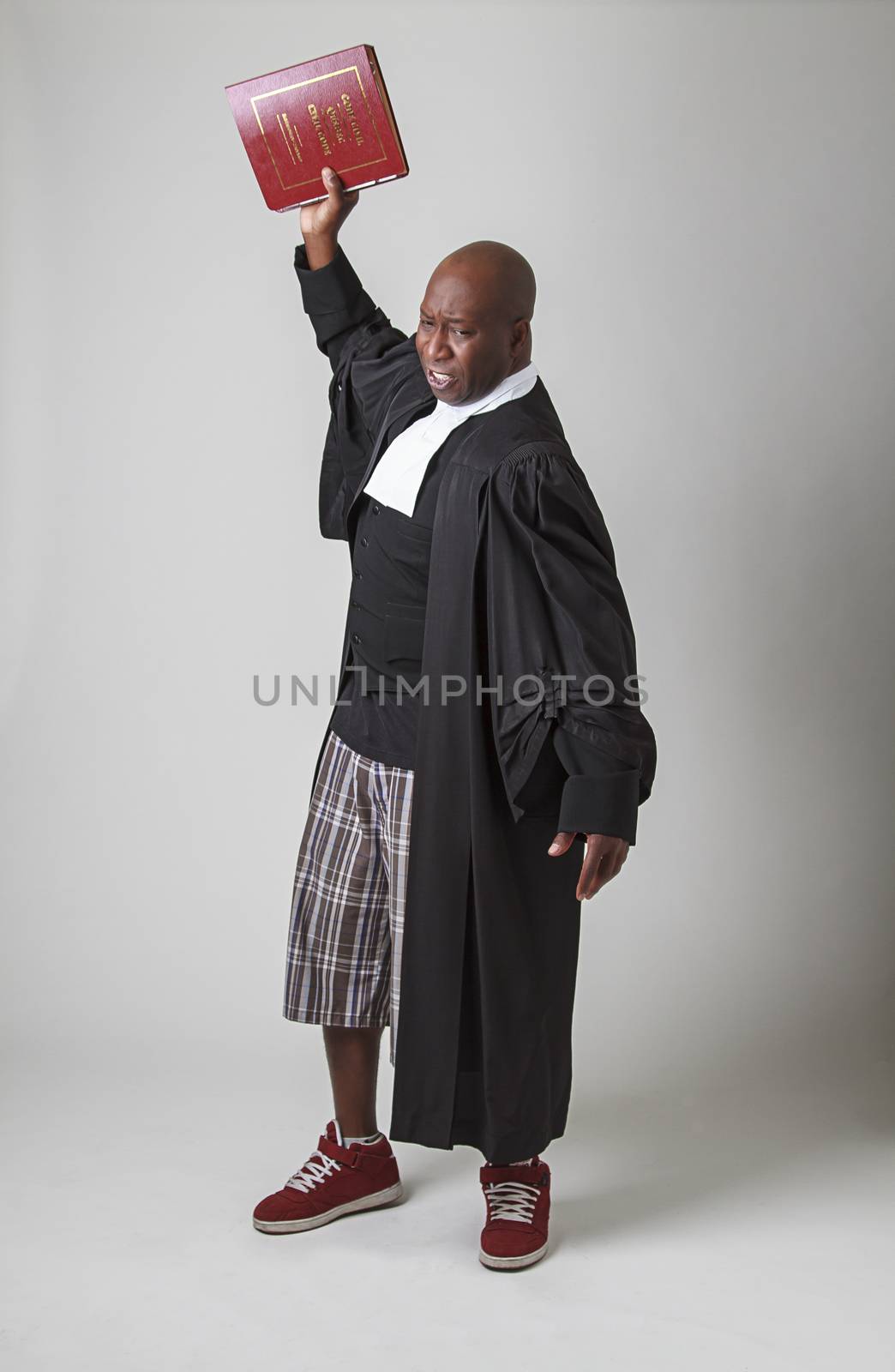 Mid-forty year old bald black man, wearing a canadian toga, throwing a red law book 