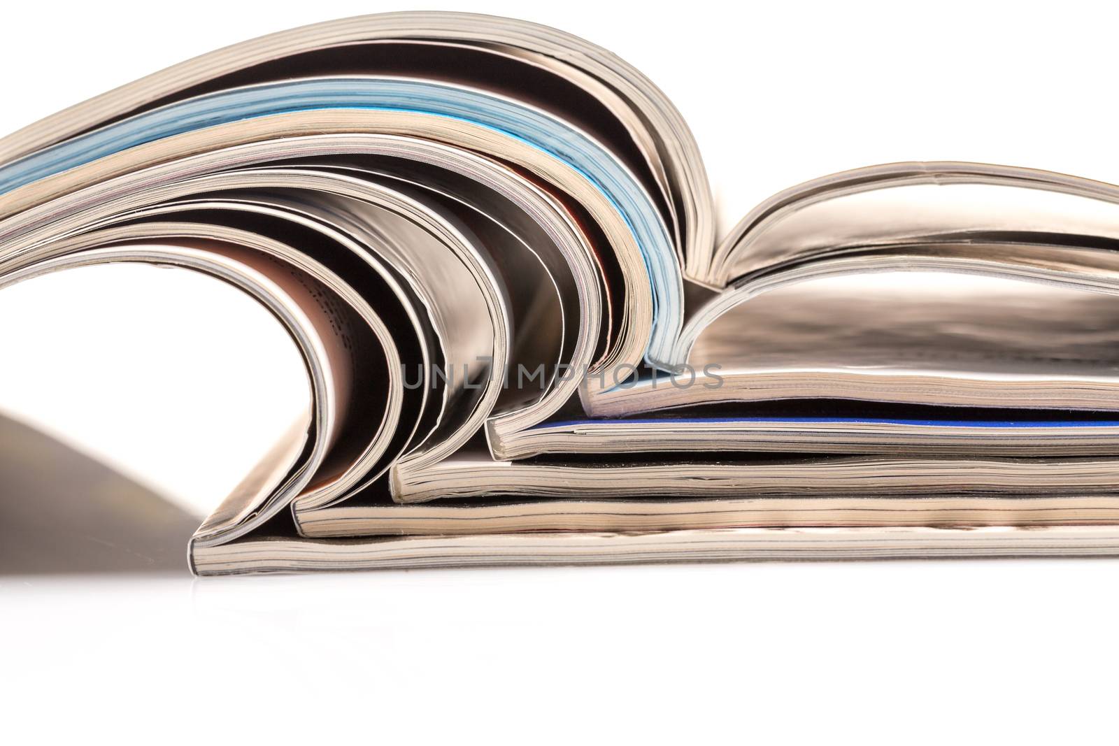 Stack of magazines on white background with reflection