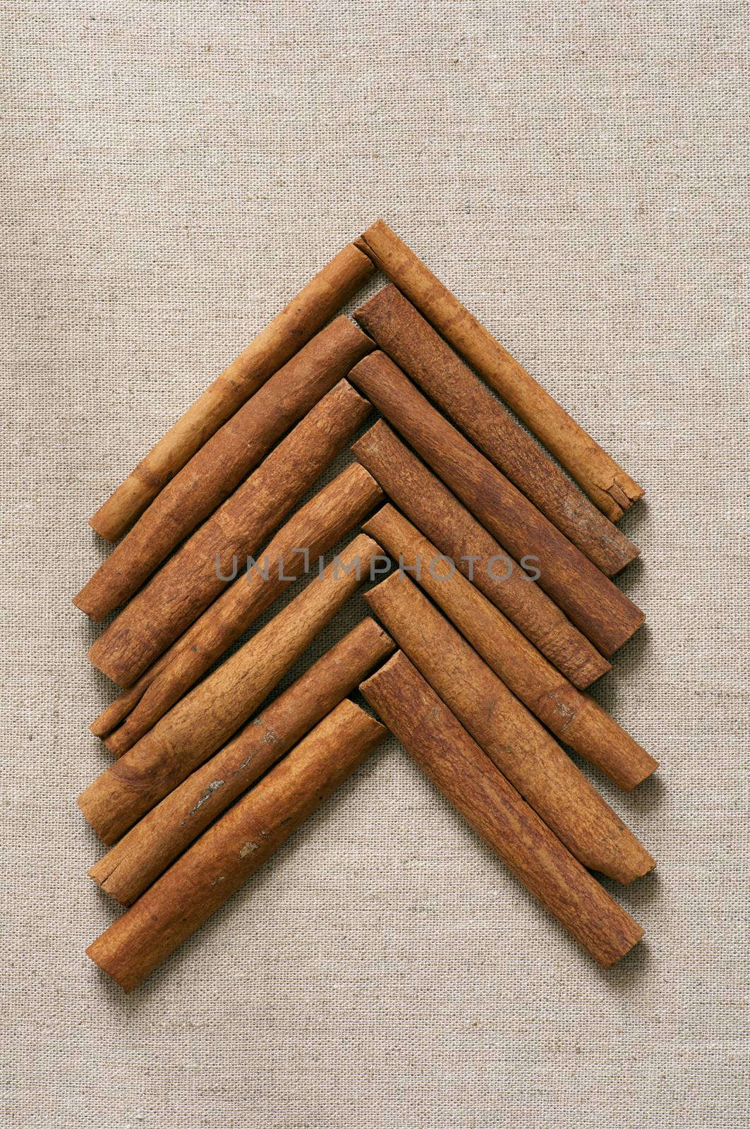 Christmas tree made of cinnamon sticks on linen background