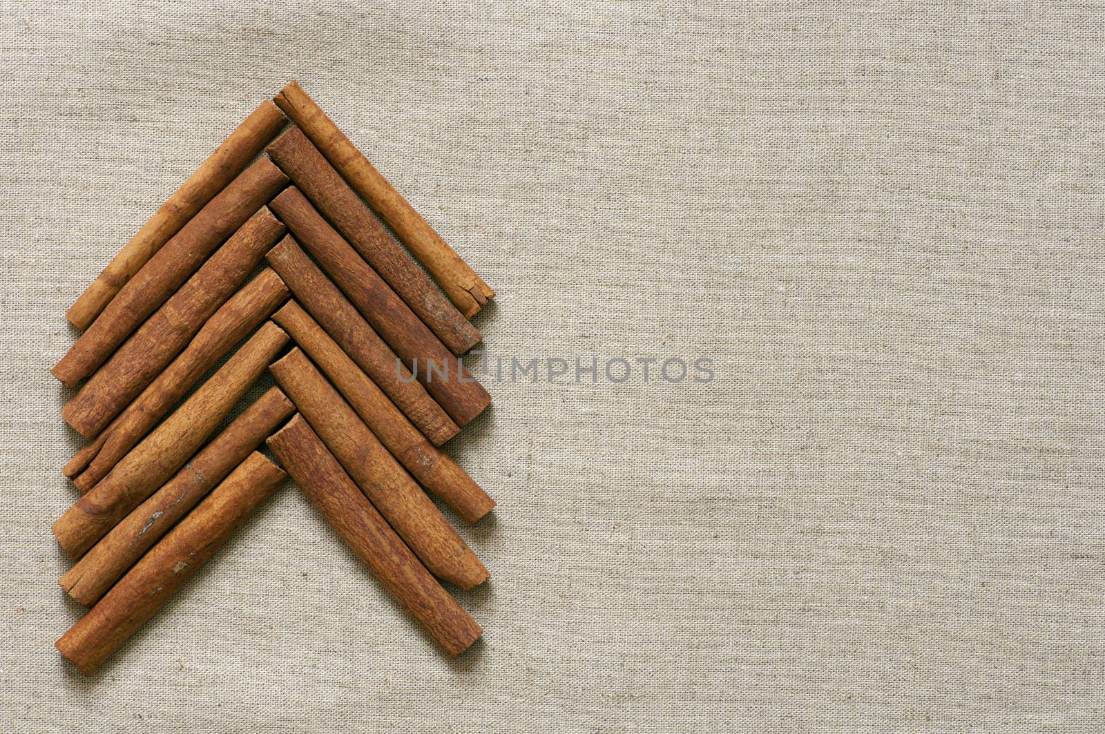 Christmas tree made of cinnamon sticks on linen background