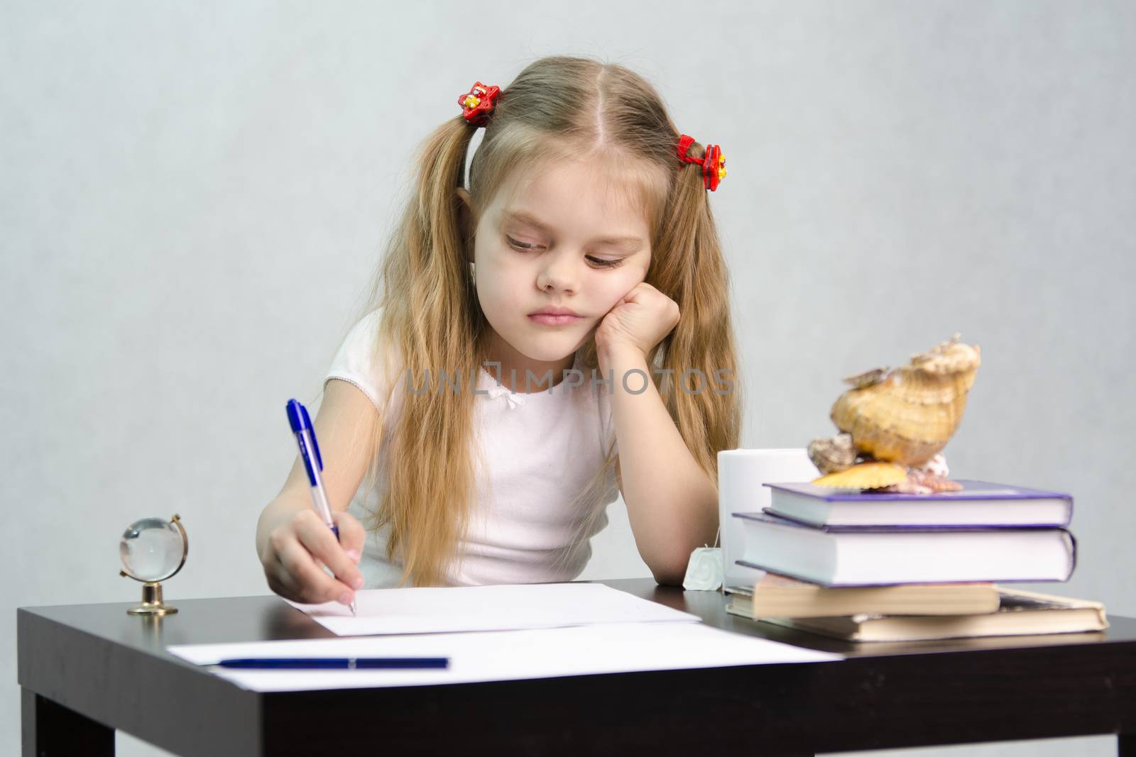 girl sits at a table and wrote on a sheet of paper. There are tombs of books, sheets of paper, a pen, glass globe, with a glass of tea, sea shell. The image of the writer