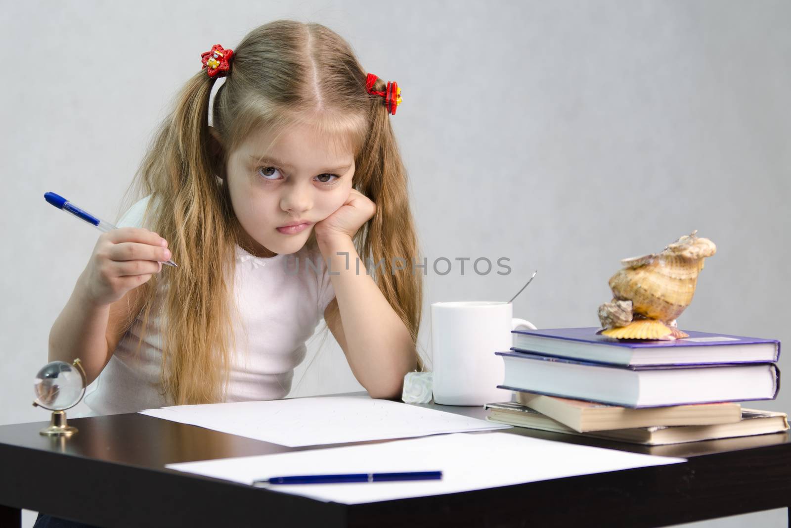 girl sits at a table and wrote on a sheet of paper. There are tombs of books, sheets of paper, a pen, glass globe, with a glass of tea, sea shell. The image of the writer