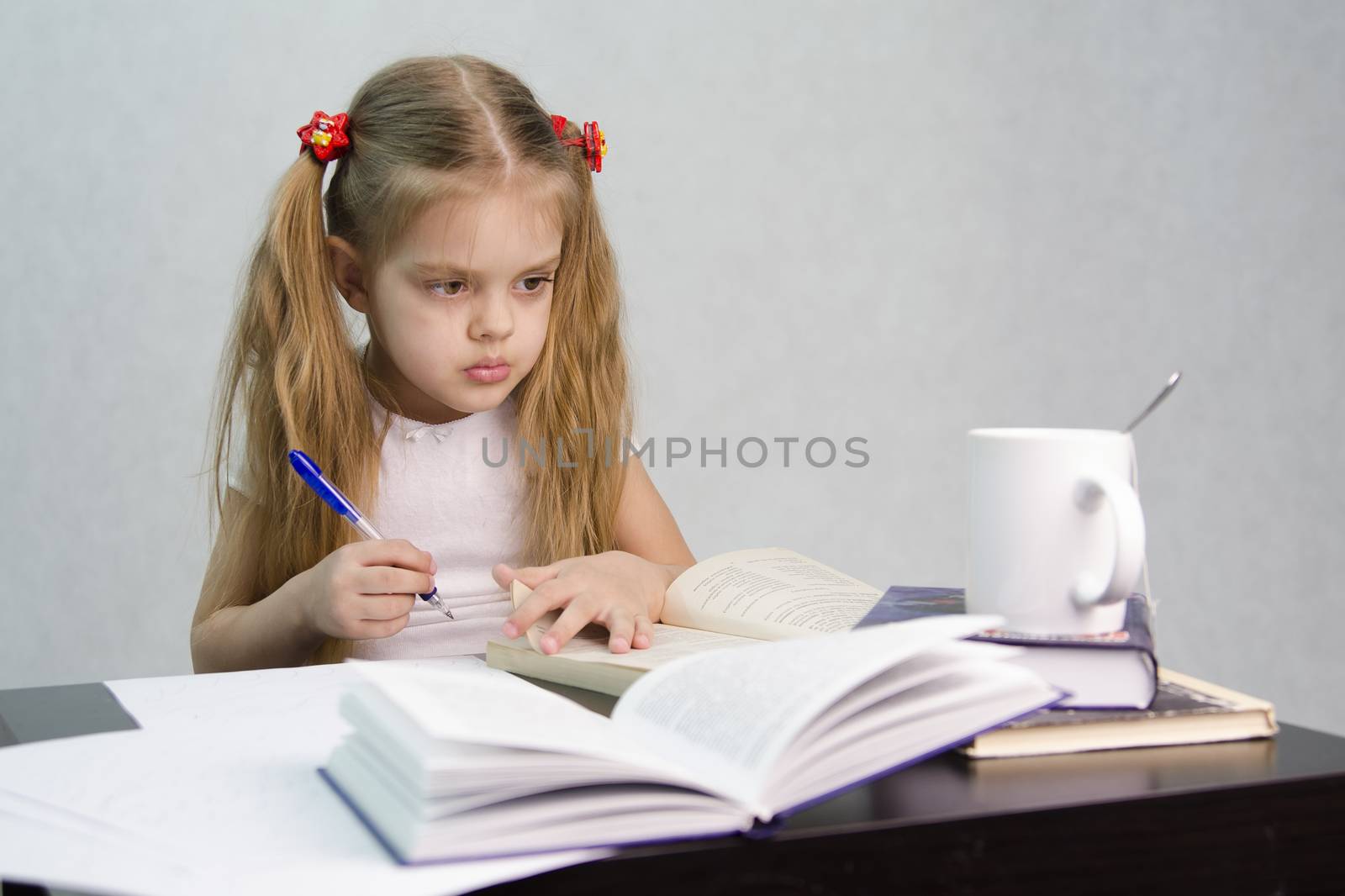 girl sits at a table and flips through the book and writes out the information you need. Next are still books, sheets of paper, a pen, a glass of tea. The image of a student, a pupil, a teacher and literary critic