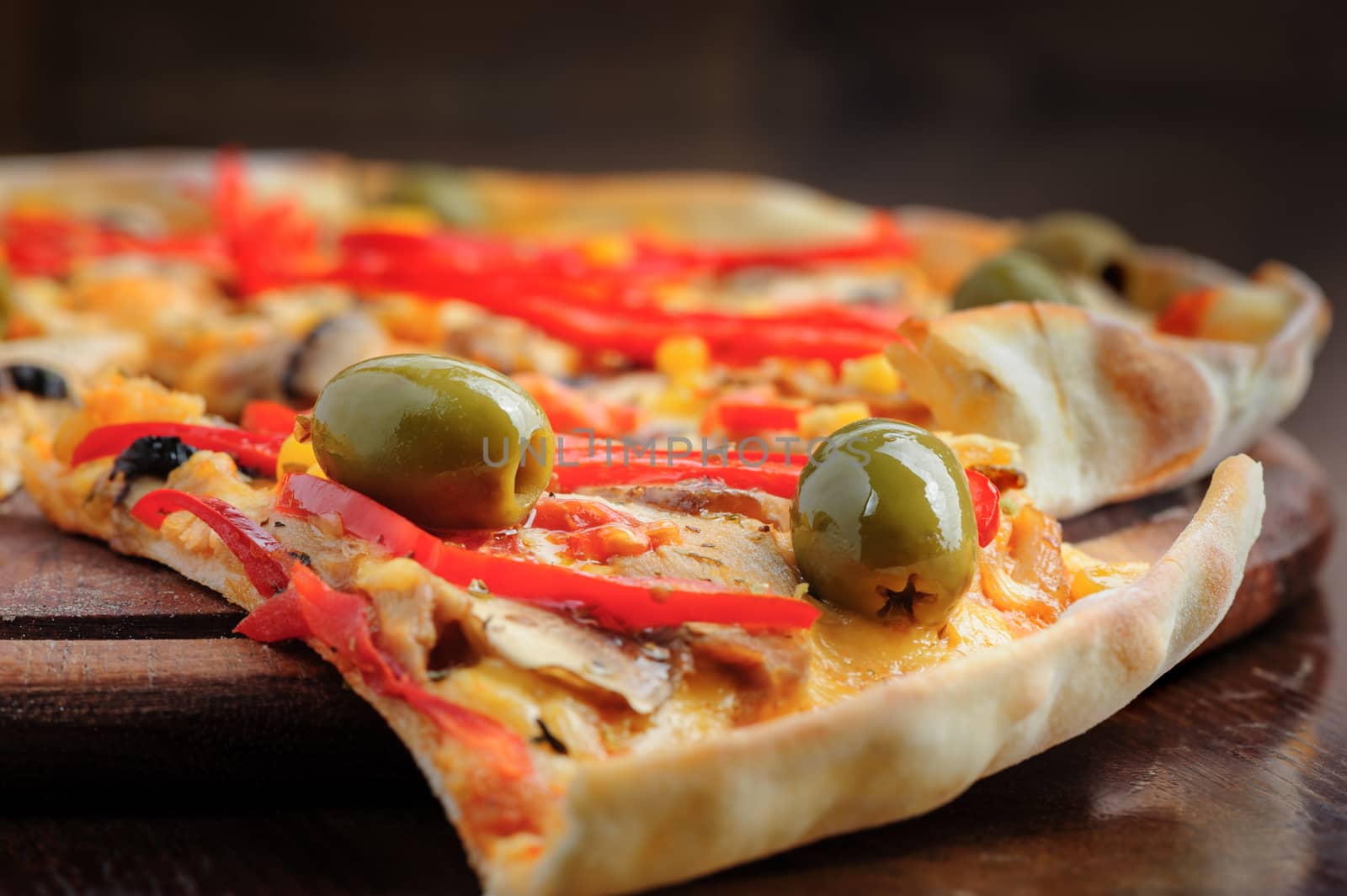 Macro closeup of pizza with mozzarella, mushrooms, olives and red bell pepper