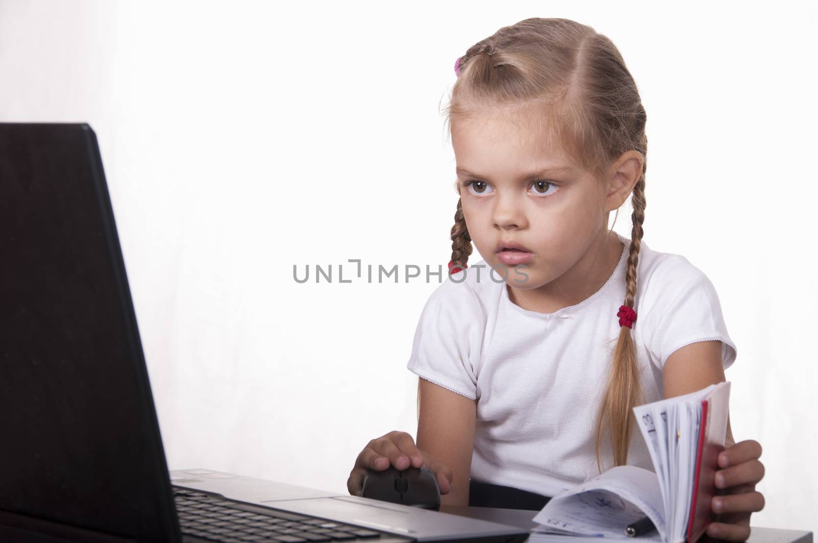 Image of a business girl. girl sitting at table. On table is a laptop, girl it works. girl joyfully looking into laptop other hand opens Notepad