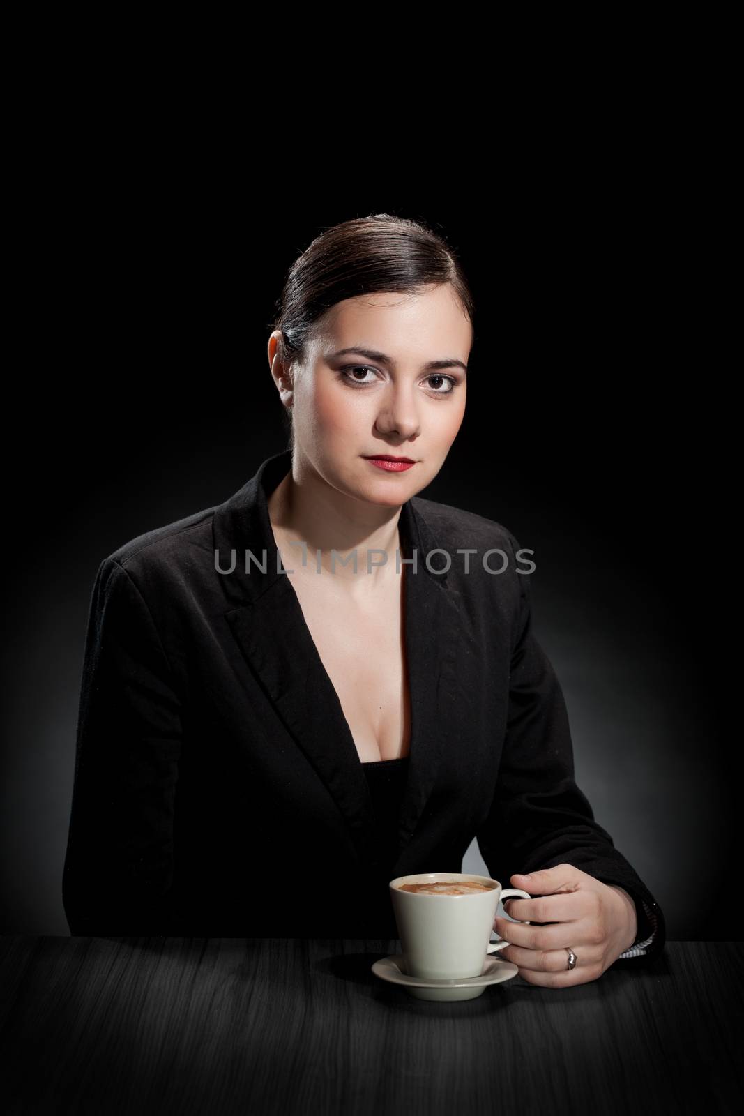 beautiful girl enjoying a cup of coffee on dark background