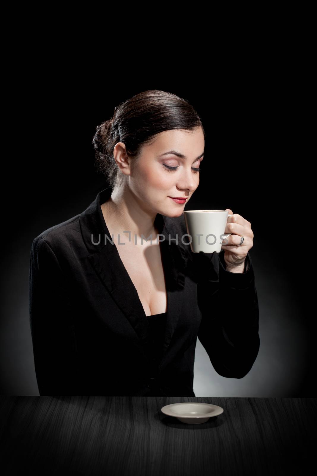 beautiful girl enjoying a cup of coffee on dark background