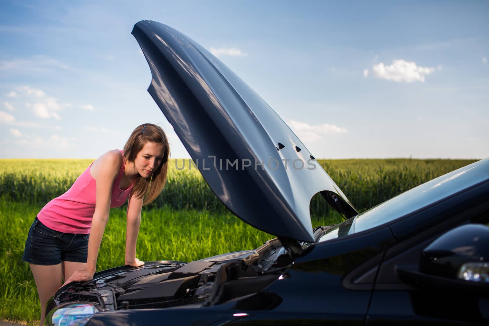 Pretty, young woman by the roadside after her car has broken dow by viktor_cap