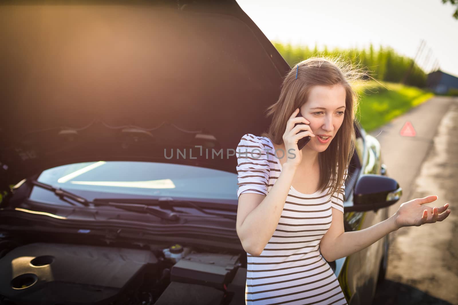 Pretty, young woman calling the roadside service/assistance by viktor_cap