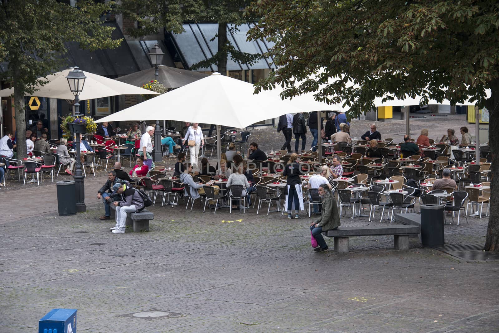 GERMANY,AACHEN - SEPT 29; 2014: Tourists Having Lunch At Outdoor Restaurant in the center of Aachen,Aachen is famous because of the dom church next to this terrace