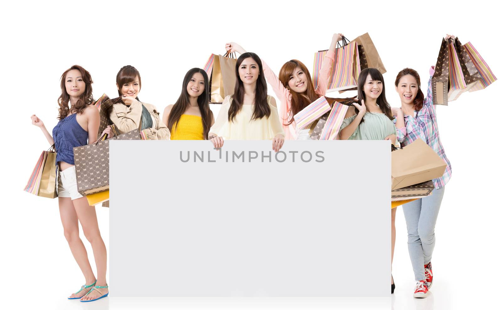 Attractive Asian woman shopping and one lady holding blank board, full length portrait isolated on white background.