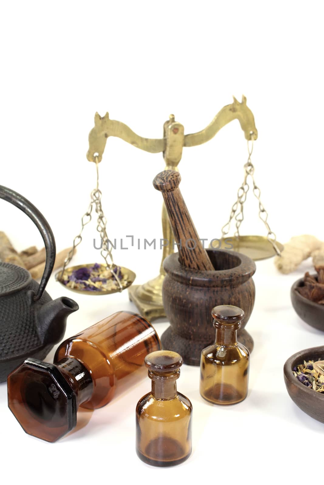 Chinese medicine with mortar and teapot on light background