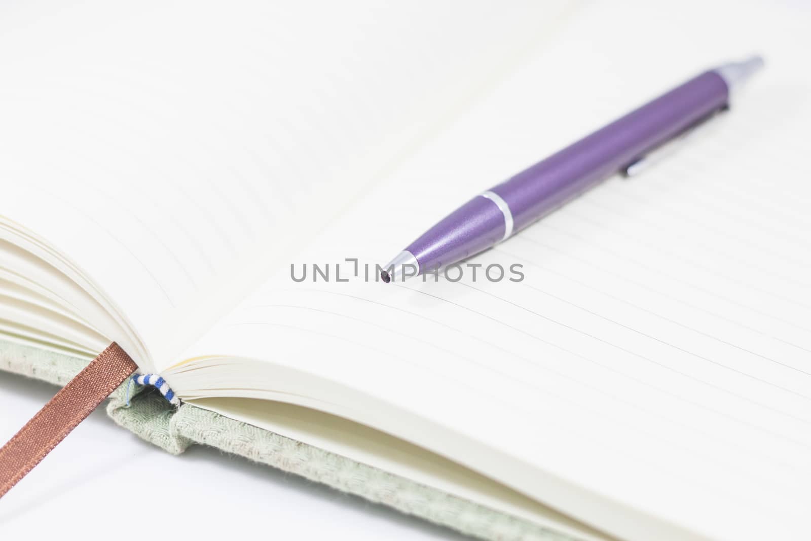 Closeup opened notebook with pen on white background, stock photo