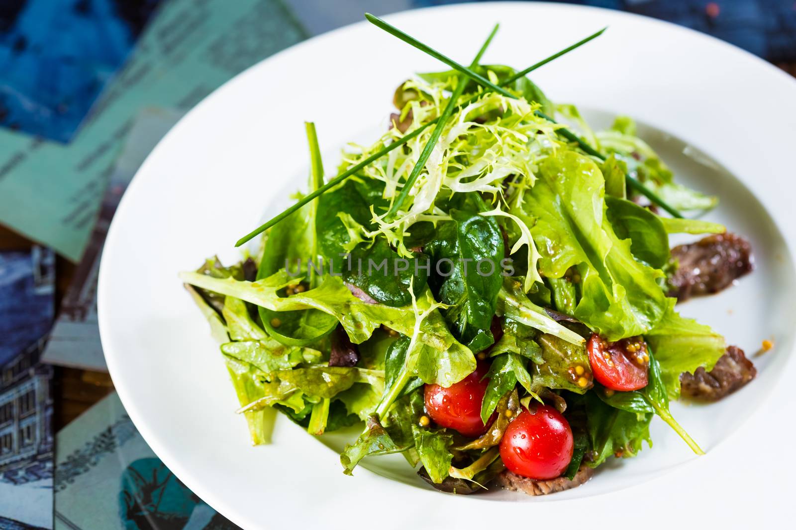 Fresh vegetable salad with meat and cherry tomatoes on white plate. by sarymsakov