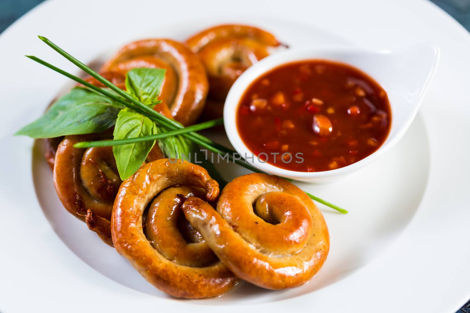 organic grilled sausages on a white plate. by sarymsakov