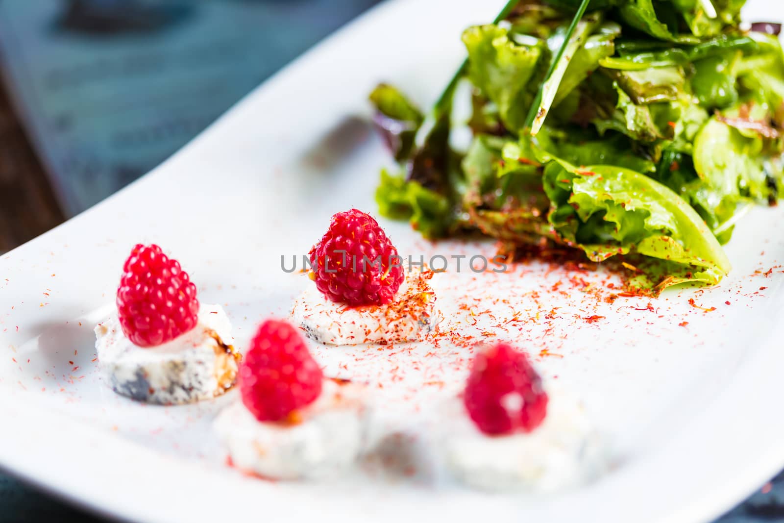 fresh salad with goat cheese and raspberry. by sarymsakov