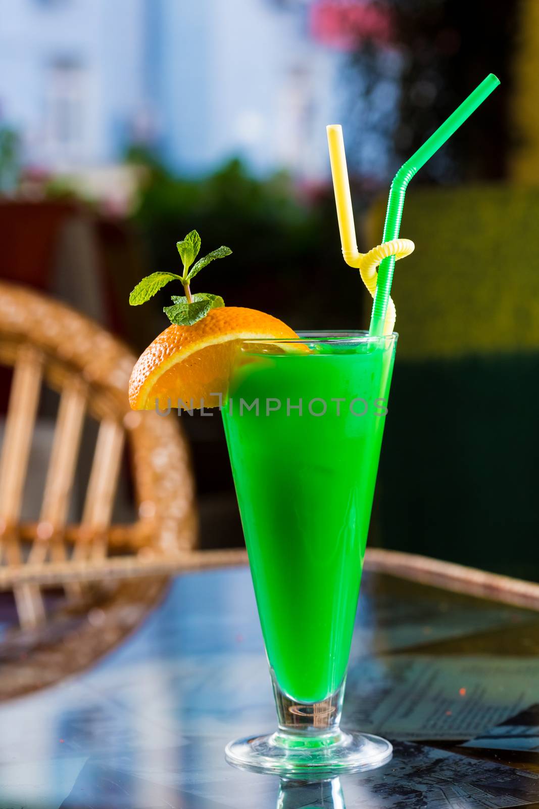 Alcoholic cocktail decorated with orange and mint leaves
