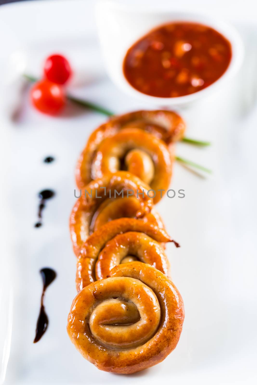 organic grilled sausages on a white plate. close-up