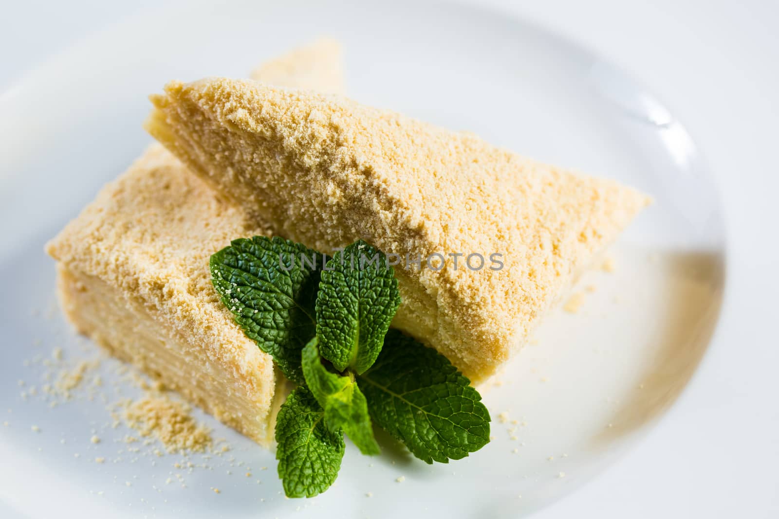 Cake Napoleon of puff pastry with sour cream on a plate. Tasty and nutritious dessert